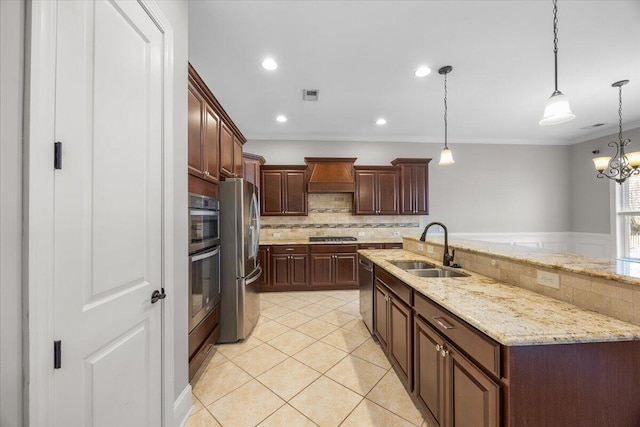 kitchen featuring hanging light fixtures, a sink, stainless steel appliances, premium range hood, and backsplash