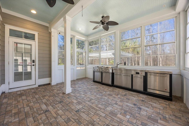 unfurnished sunroom with ceiling fan