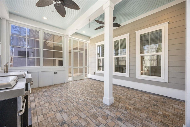 unfurnished sunroom featuring ceiling fan