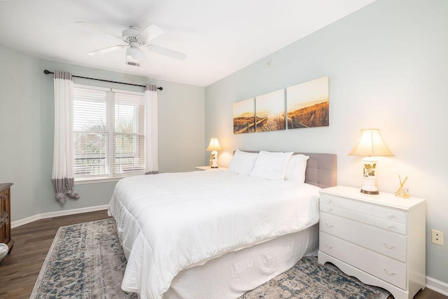 bedroom with dark wood-type flooring, a ceiling fan, and baseboards