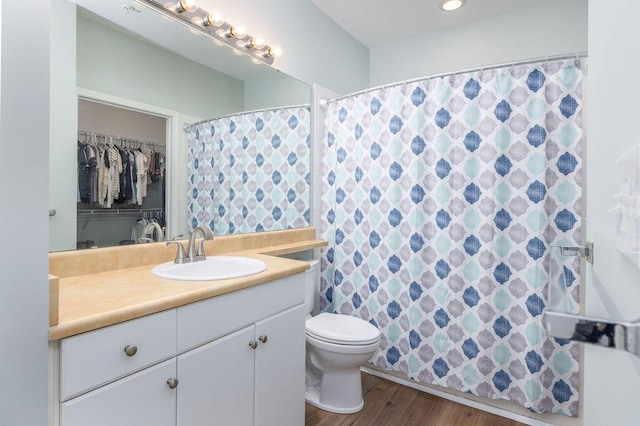 full bathroom featuring toilet, vanity, wood finished floors, and curtained shower