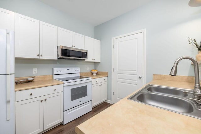 kitchen with dark wood-style flooring, white cabinetry, a sink, and white appliances
