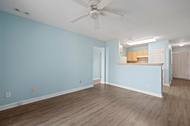 unfurnished living room featuring dark hardwood / wood-style flooring and ceiling fan