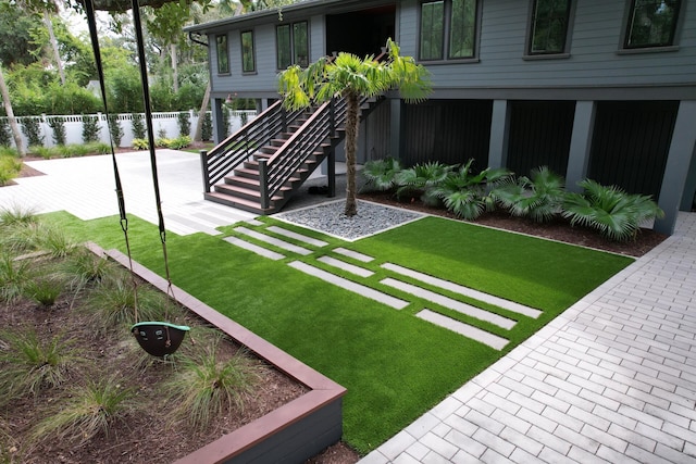 view of yard with a patio area, stairs, and fence