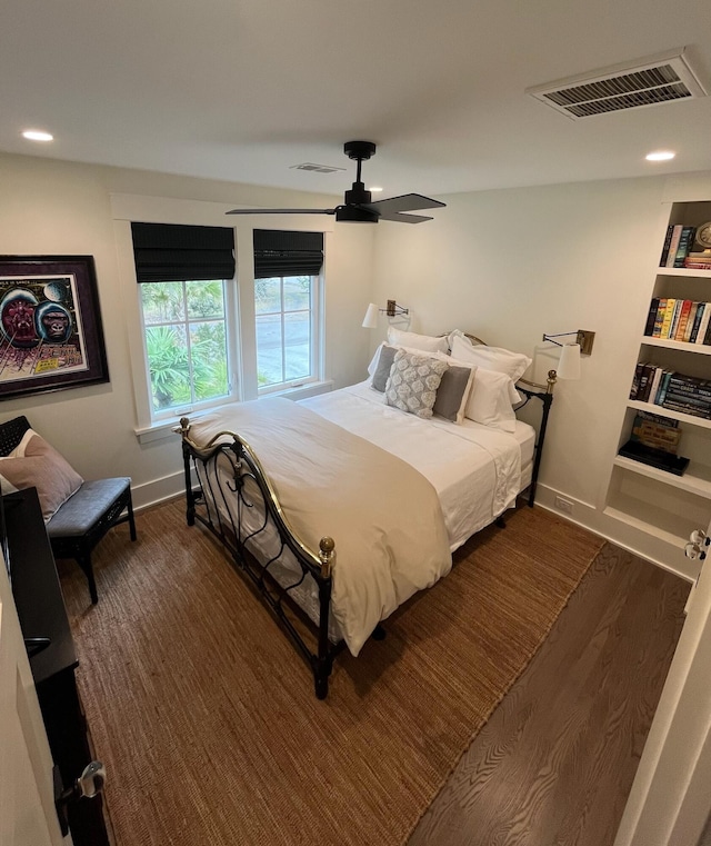 bedroom with ceiling fan, visible vents, baseboards, and dark wood finished floors