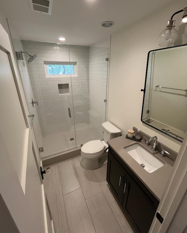 full bathroom featuring visible vents, toilet, a stall shower, and vanity