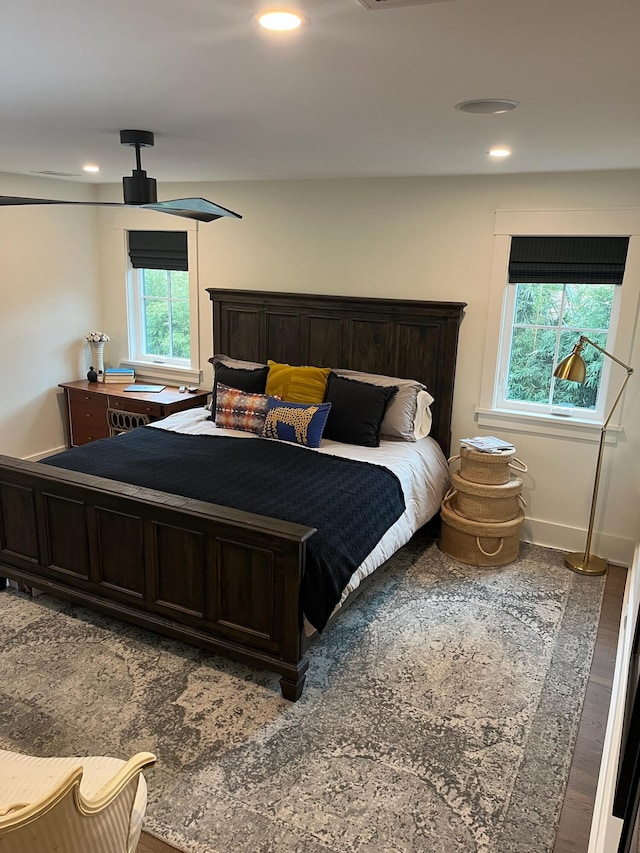 bedroom with recessed lighting, wood finished floors, and baseboards