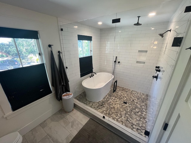 full bath featuring a wealth of natural light, a soaking tub, and a stall shower