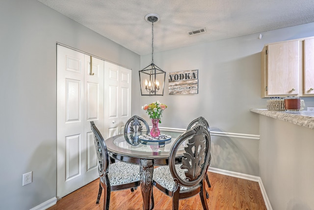 188 Midland Pkwy Unit 516, Summerville, SC 29485 - dining area with baseboards, a chandelier, wood finished floors, and a textured ceiling