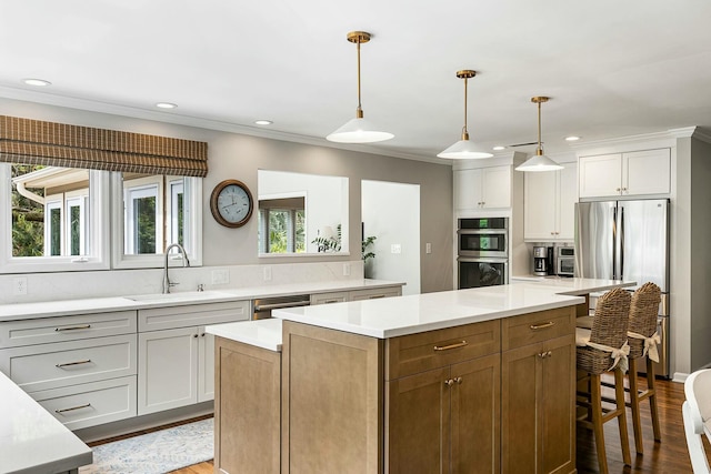 kitchen featuring recessed lighting, stainless steel appliances, a sink, and a kitchen island