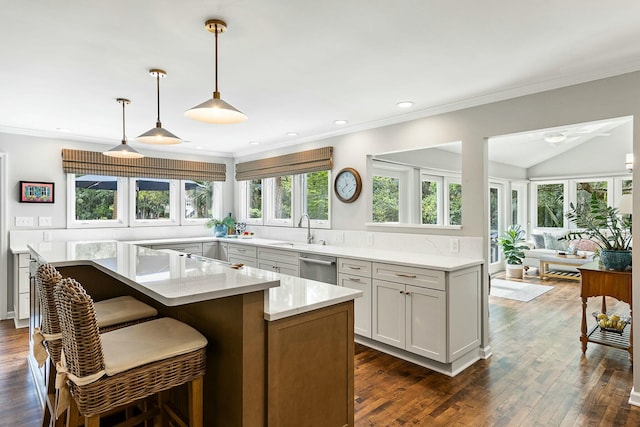 kitchen featuring a wealth of natural light, dishwasher, a sink, and a breakfast bar area