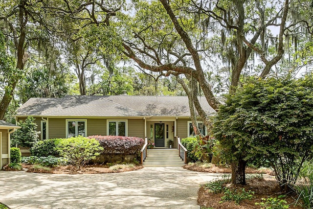 single story home with roof with shingles and concrete driveway