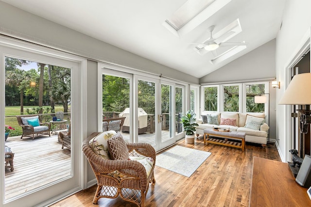 sunroom featuring a wooden deck, french doors, lofted ceiling with skylight, and a healthy amount of sunlight
