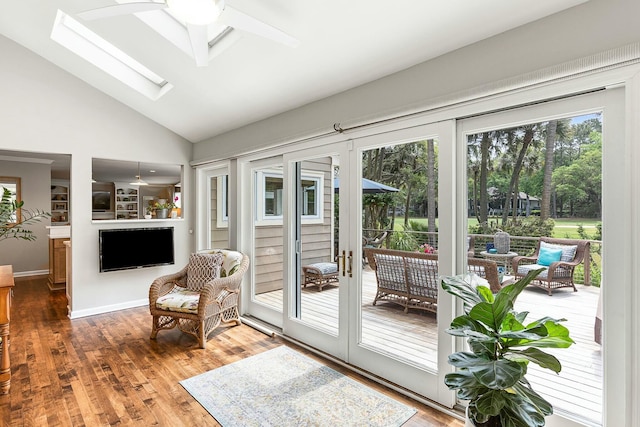 entryway with high vaulted ceiling, a ceiling fan, wood finished floors, and a skylight