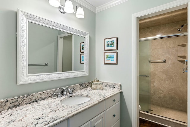 bathroom with vanity, crown molding, a stall shower, and toilet