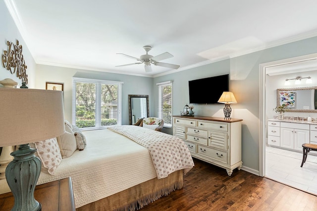 bedroom with dark wood-style floors, ornamental molding, a sink, ceiling fan, and ensuite bathroom