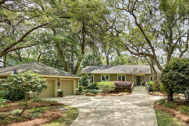 ranch-style home with driveway, roof with shingles, and a garage