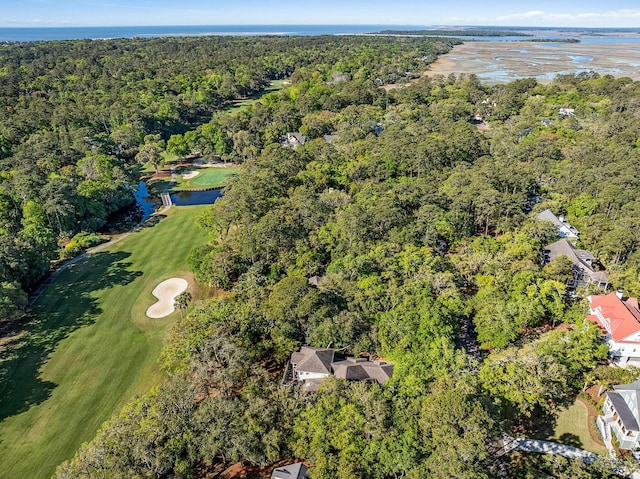 aerial view featuring golf course view, a wooded view, and a water view