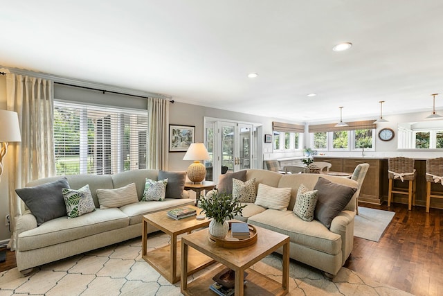 living room featuring hardwood / wood-style flooring, a wealth of natural light, and ornamental molding