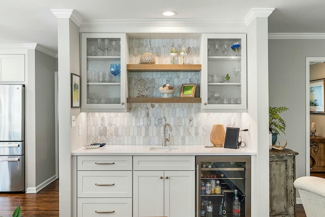 bar featuring a sink, wet bar, dark wood-style flooring, wine cooler, and freestanding refrigerator