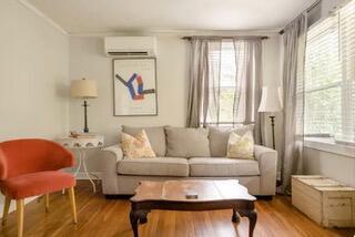 sitting room featuring an AC wall unit, a healthy amount of sunlight, light hardwood / wood-style floors, and ornamental molding