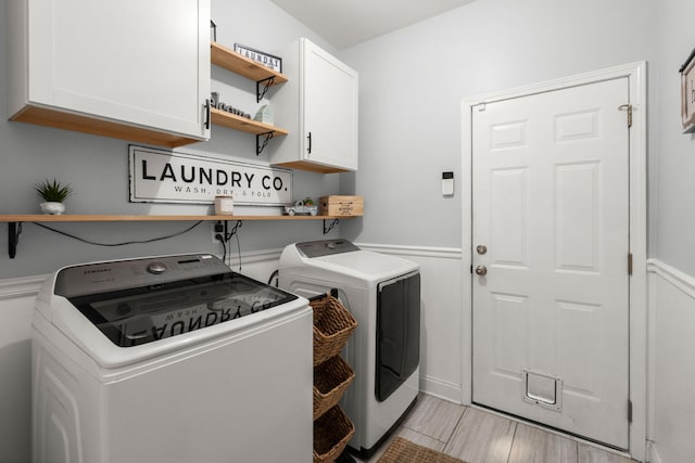 7030 Billberry St, Hanahan, SC 29410 - laundry room featuring separate washer and dryer, cabinet space, light wood-style floors, and a wainscoted wall