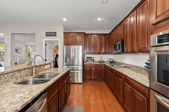 7030 Billberry St, Hanahan, SC 29410 - kitchen with appliances with stainless steel finishes, light wood-style flooring, light stone counters, and recessed lighting