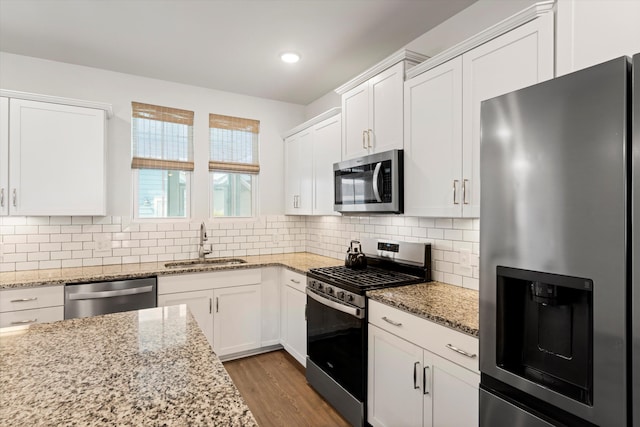 557 Blueway Ave, Summerville, SC 29486 - kitchen with stainless steel appliances, a sink, white cabinets, wood finished floors, and recessed lighting