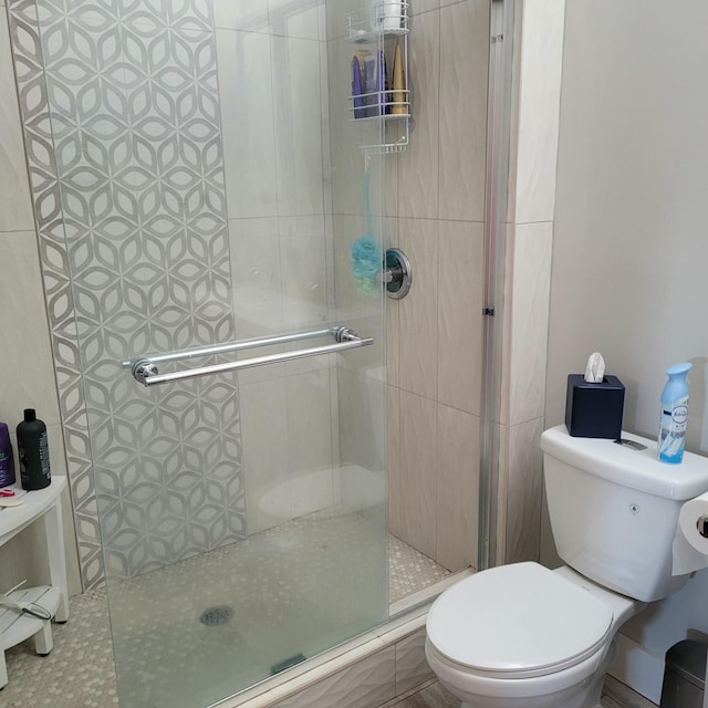 full bath with toilet and a stall shower
