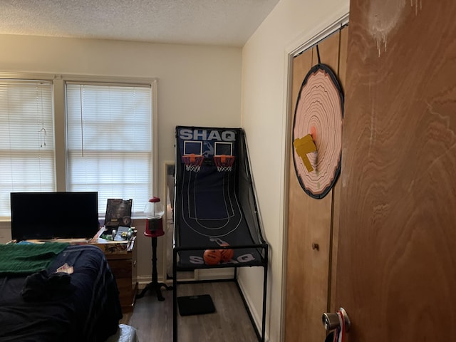 bedroom with dark hardwood / wood-style flooring and a textured ceiling