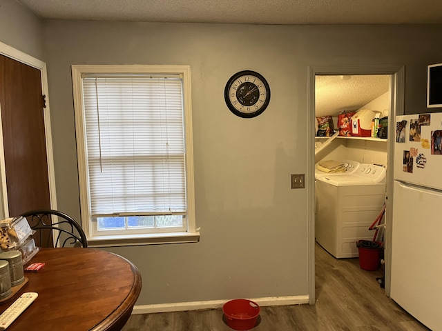 dining space featuring hardwood / wood-style flooring, washing machine and dryer, and a textured ceiling