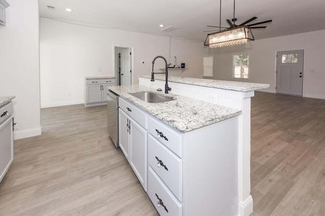 kitchen with pendant lighting, sink, stainless steel dishwasher, ceiling fan, and an island with sink