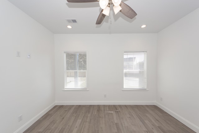 spare room with ceiling fan, plenty of natural light, and light hardwood / wood-style flooring