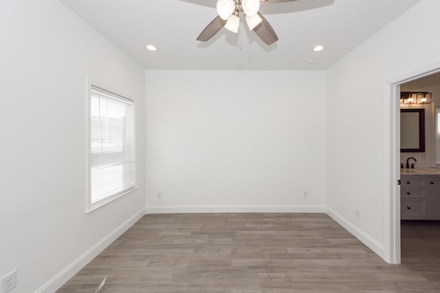 unfurnished room featuring ceiling fan, sink, and light hardwood / wood-style flooring