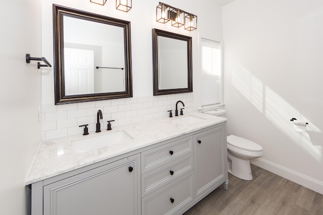 bathroom with decorative backsplash, hardwood / wood-style floors, vanity, and toilet