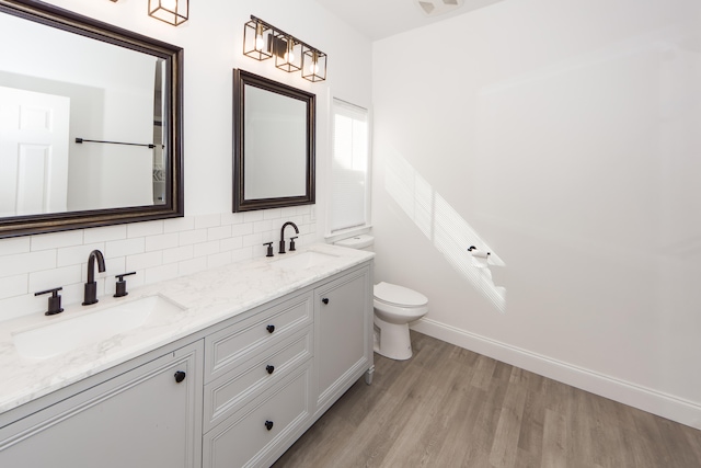 bathroom featuring tasteful backsplash, toilet, vanity, and hardwood / wood-style flooring