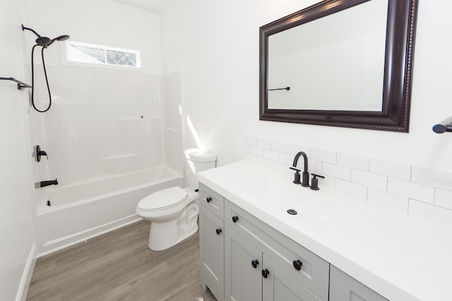 full bathroom featuring vanity, backsplash, shower / washtub combination, toilet, and wood-type flooring