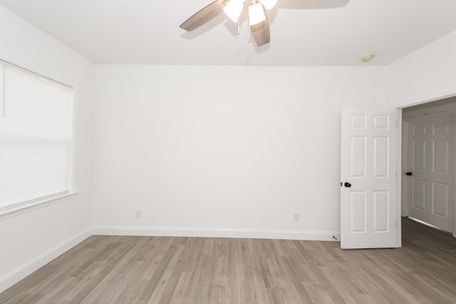 empty room with ceiling fan and light hardwood / wood-style flooring