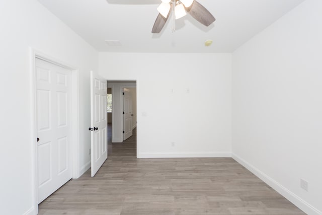 empty room with light hardwood / wood-style flooring and ceiling fan