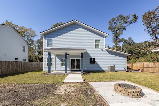 rear view of house with ceiling fan, a yard, a fire pit, central air condition unit, and a patio area