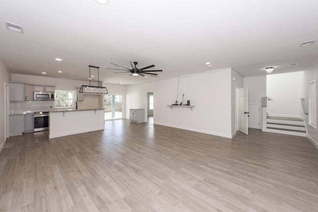 unfurnished living room featuring hardwood / wood-style flooring and ceiling fan