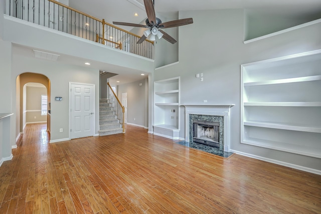 9379 Harroway Rd, Summerville, SC 29485 - unfurnished living room featuring a towering ceiling, a high end fireplace, a ceiling fan, baseboards, and built in shelves