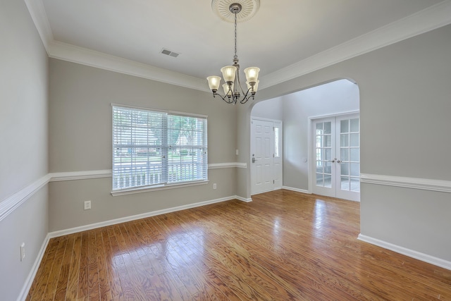 9379 Harroway Rd, Summerville, SC 29485 - spare room featuring an inviting chandelier, wood finished floors, visible vents, ornamental molding, and arched walkways