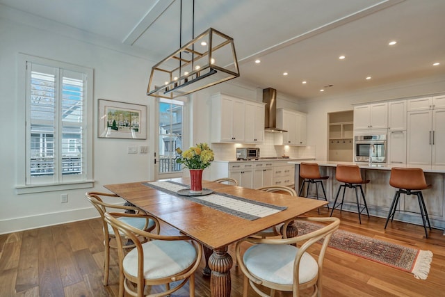 dining room with a toaster, recessed lighting, wood finished floors, and baseboards