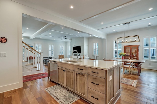 kitchen featuring beamed ceiling, an island with sink, a sink, hardwood / wood-style floors, and dishwasher