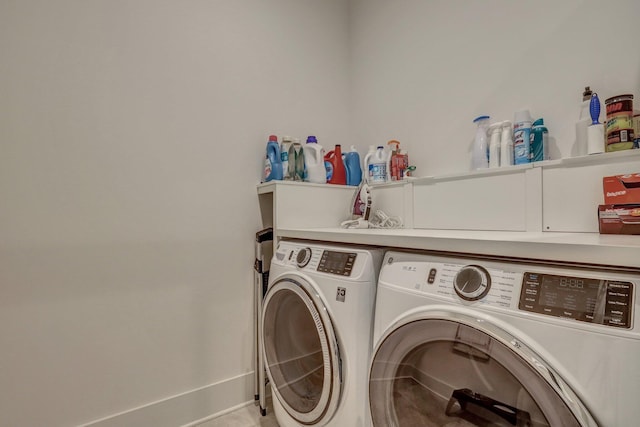 washroom with baseboards, laundry area, and washing machine and clothes dryer