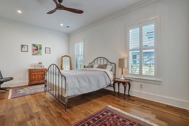 bedroom featuring visible vents, baseboards, ornamental molding, recessed lighting, and wood finished floors