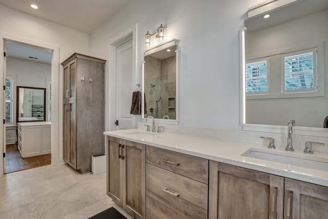 full bath with double vanity, recessed lighting, a shower stall, and a sink