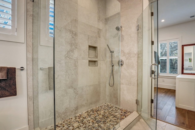 full bathroom featuring visible vents, a shower stall, and hardwood / wood-style flooring