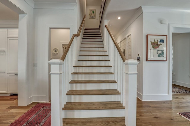 staircase with recessed lighting, baseboards, and wood finished floors